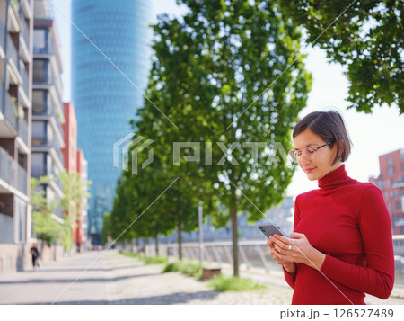 Woman in glasses stands in center of Frankfurt, 126527489