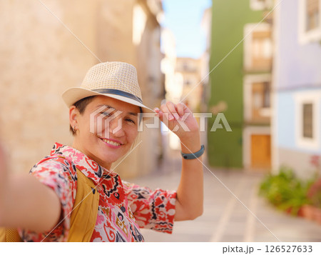 Woman strolls through colorful streets of Spanish coastal town Woman strolls through colorful streets of Spanish coastal town 126527633