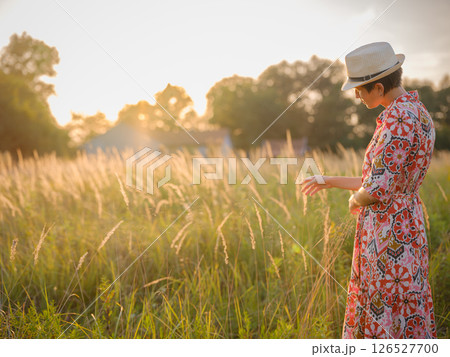 boho chic woman in a floral dress in European countryside boho chic woman in a floral dress in European countryside 126527700