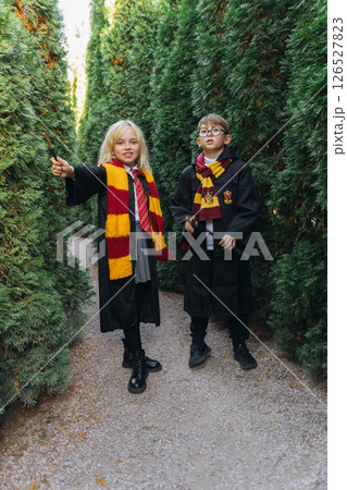 Children Harry Potter Costumes Maze - Two children dressed as Harry Potter characters stand in a maze. Children Harry Potter Costumes Maze - Two children dressed as Harry Potter characters stand in a maze. 126527823