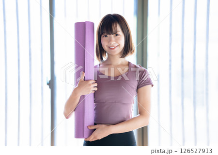 ヨガマットを持つ若い女性 126527913