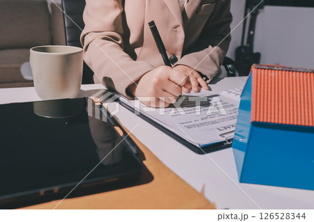 Female Real Estate Broker presenting and advised to model home and building project detail in the office, sign purchase sales contract, agreements concerned mortgage loan offer and insurance. 126528344