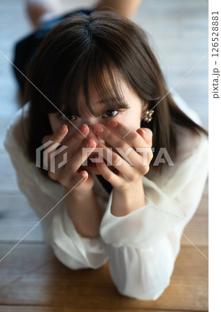 フローリングに寝転ぶ若い女性 フローリングに寝転ぶ若い女性 126528881