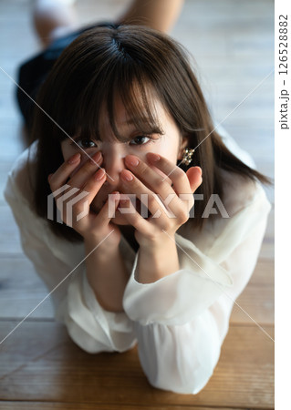 フローリングに寝転ぶ若い女性 126528882