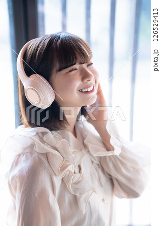 ヘッドホンで音楽を聴く若い女性のアップ 126529413