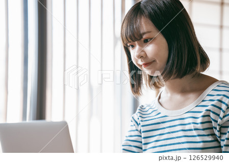 和室でノートパソコンを使う若い女性 和室でノートパソコンを使う若い女性 126529940