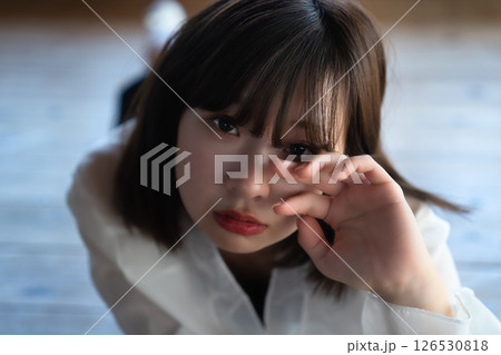 フローリングに寝転ぶ若い女性 フローリングに寝転ぶ若い女性 126530818