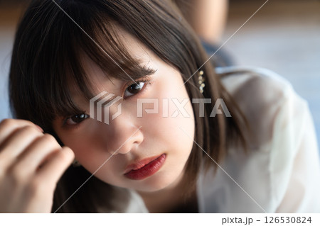 フローリングに寝転ぶ若い女性 126530824