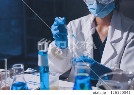 Scientist pipetting medical samples into microplate in laboratory Scientist pipetting medical samples into microplate in laboratory 126530841