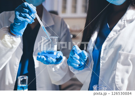 Scientist pipetting medical samples into microplate in laboratory Scientist pipetting medical samples into microplate in laboratory 126530884