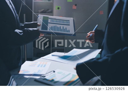 Group of business women working on a financial data expenses document. Group of business women working on a financial data expenses document. 126530926