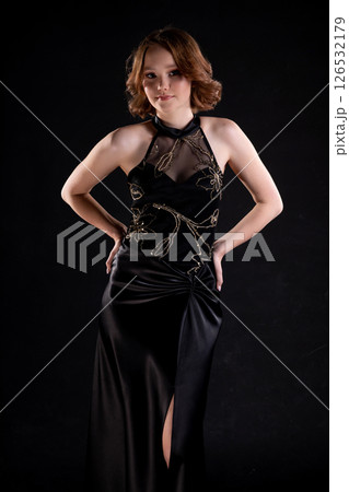 This evening dress showcases an elegant design worn by a stunning model in a captivating pose 126532179