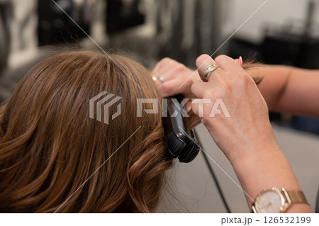 Masterful Hair Curling Technique in a Sophisticated Salon Environment with Professional Appeal 126532199