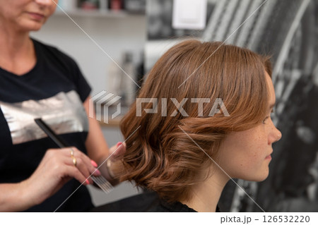 Experience the art of hair styling in progress at a chic and trendy salon boutique Experience the art of hair styling in progress at a chic and trendy salon boutique 126532220