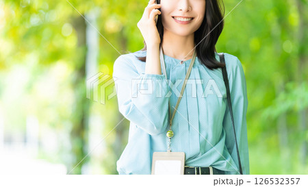 スマートフォンで話す笑顔の女性・ビジネスウーマン 126532357