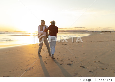 Senior couple dancing together on the beach at sunset 126532474