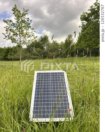Solar panel is sitting in a field of grass Solar panel is sitting in a field of grass 126532767