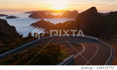Epic Sunset View in High Mountain Landscape with Asphalt Road . Pico do Arieiro , Madeira Island . Clouds in the Valley . Epic Sunset View in High Mountain Landscape with Asphalt Road . Pico do Arieiro , Madeira Island . Clouds in the Valley . 126532772