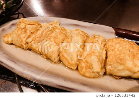 close up of Japanese pan fried egg omelette rolls (Tamagoyaki) cut into pieces on a white plate 126533442