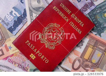 International passport of a citizen of Italy on background of paper banknotes International passport of a citizen of Italy on background of paper banknotes 126533976
