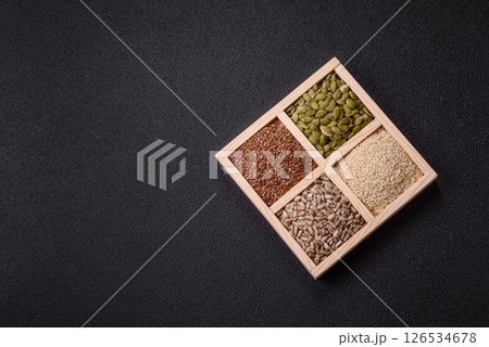 Sunflower, pumpkin, flax and sesame seeds in a wooden box 126534678