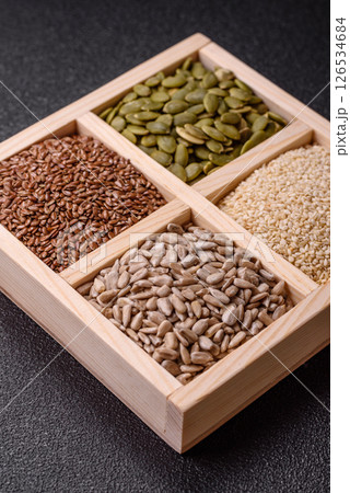 Sunflower, pumpkin, flax and sesame seeds in a wooden box Sunflower, pumpkin, flax and sesame seeds in a wooden box 126534684