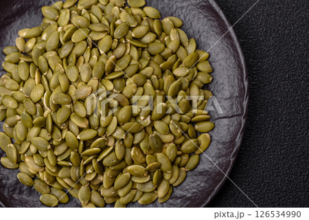 Peeled pumpkin seeds in a bowl, an ingredient for making vegetarian food Peeled pumpkin seeds in a bowl, an ingredient for making vegetarian food 126534990