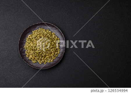 Peeled pumpkin seeds in a bowl, an ingredient for making vegetarian food Peeled pumpkin seeds in a bowl, an ingredient for making vegetarian food 126534994