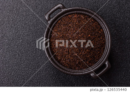 Black tea dry crushed in bowl 126535440