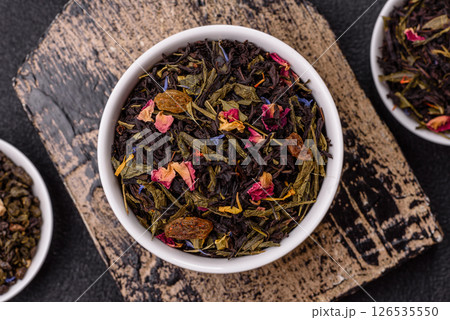 Dry tea mix blend black, green and flower petals in bowl Dry tea mix blend black, green and flower petals in bowl 126535550