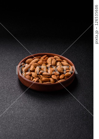 Roasted or raw almond nuts in shell in bowl 126535686