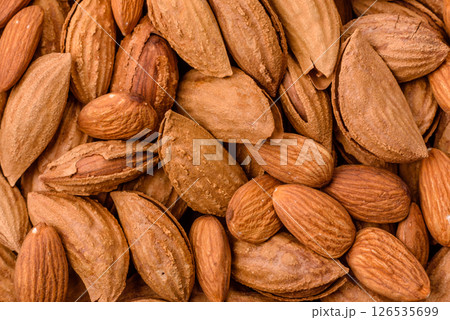 Roasted or raw almond nuts in shell in bowl 126535699