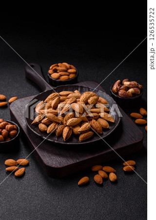 Roasted or raw almond nuts in shell in bowl 126535722