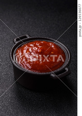 Red sauce or ketchup with salt and spices in ceramic sauce boat 126536077