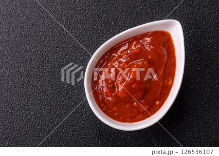 Red sauce or ketchup with salt and spices in ceramic sauce boat 126536107