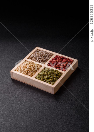 A box of peanuts and cedar nuts and sunflower and pumpkin seeds 126536315