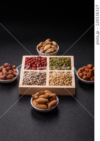 A box of peanuts and cedar nuts and sunflower and pumpkin seeds 126536327