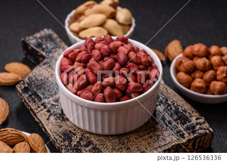 Peanuts or peeled graundnut in a bowl on a dark concrete background Peanuts or peeled graundnut in a bowl on a dark concrete background 126536336
