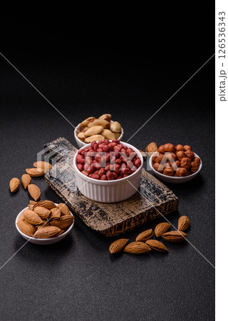 Peanuts or peeled graundnut in a bowl on a dark concrete background Peanuts or peeled graundnut in a bowl on a dark concrete background 126536343