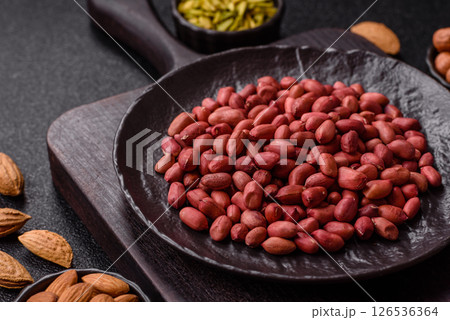 Peanuts or peeled graundnut in a bowl on a dark concrete background 126536364
