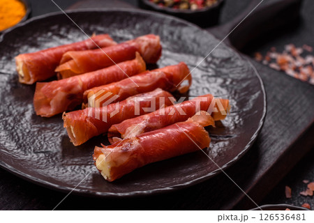 Cheese and meat, jamon or prosciutto rolled into a roll 126536481