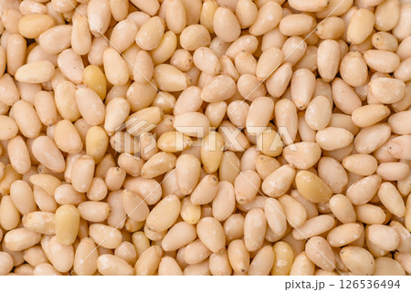 Peeled pine nuts in a bowl on a dark concrete background Peeled pine nuts in a bowl on a dark concrete background 126536494