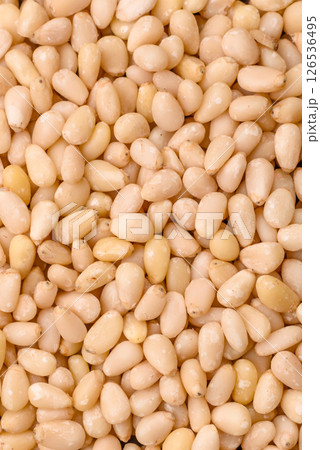 Peeled pine nuts in a bowl on a dark concrete background Peeled pine nuts in a bowl on a dark concrete background 126536495