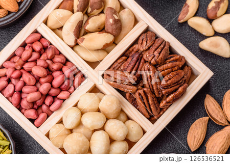 Wooden box with macadamia nuts, Brazil nuts, pecans and peanuts 126536521