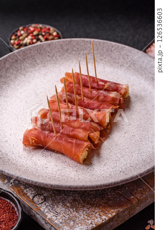 Cheese and meat, jamon or prosciutto rolled into a roll 126536603