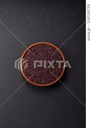 Red or brown raw rice in a ceramic bowl 126536728