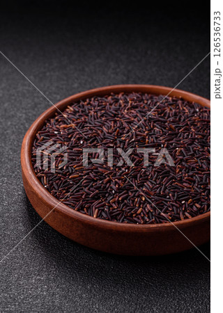 Red or brown raw rice in a ceramic bowl 126536733