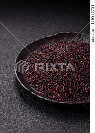 Red or brown raw rice in a ceramic bowl 126536751
