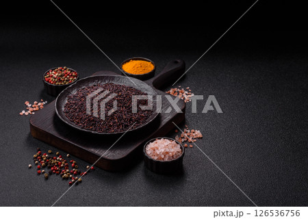 Red or brown raw rice in a ceramic bowl 126536756