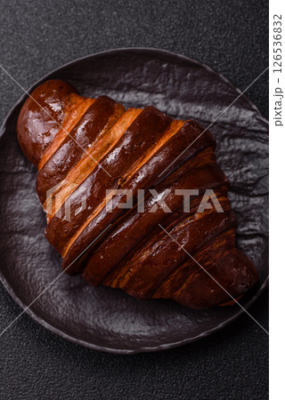 Sweet fresh crispy croissant with chocolate filling 126536832